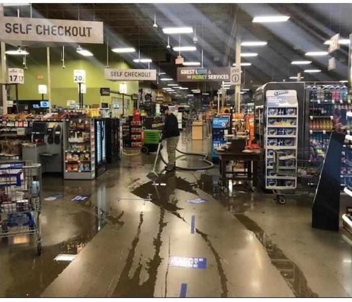 technician extracting water in retail space