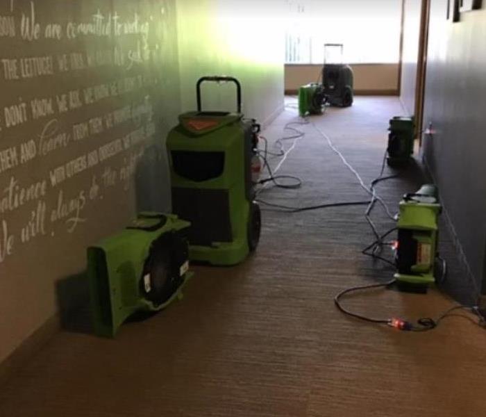 equipment set up in the hallway of a commercial building after a water loss